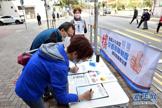 3月11日,在香港街头,香港市民签名支持。新华社记者 卢炳辉 摄