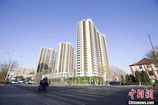 资料图:市民从一封顶楼盘前经过。 记者 张云 摄