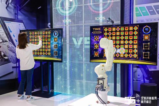 2020年南京创新周·5G+全球创新应用南京峰会现场,一位市民正在和5G+AI机器人pk消消乐游戏。主办方供
