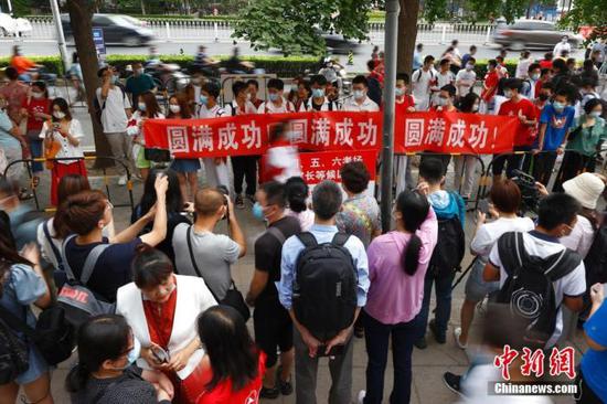 6月7日,北京人大附中考点外,送考同学为考生拉横幅加油。 中新社记者 富田 摄