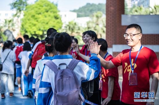 6月7日,在贵州省贵阳市乌当中学考点外,送考老师与考生击掌。新华社记者 陶亮 摄