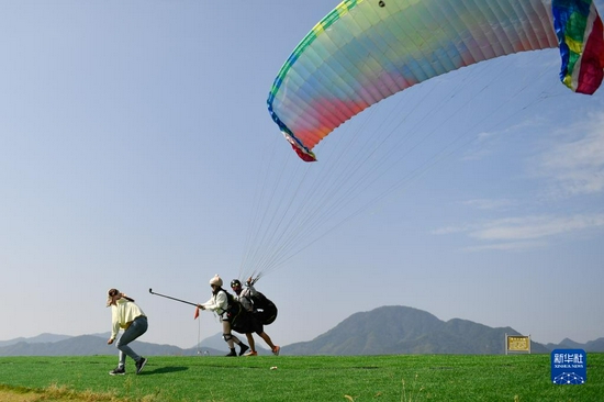 10月2日,游客在浙江省桐庐县钟山乡金家山滑翔伞基地体验滑翔伞。新华社记者 黄宗治 摄