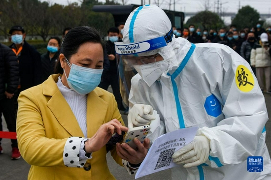 12月8日,在浙江省宁波市镇海区大学生创业园核酸检测点,医护人员查看参检人员信息。新华社发(胡学军摄)