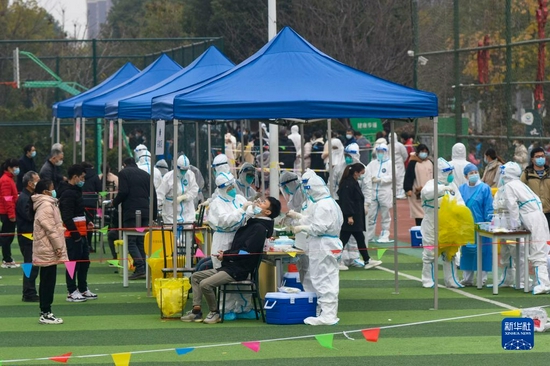 12月8日,在浙江省宁波市镇海区中官路体育公园核酸检测点,人们接受核酸采样。新华社发(胡学军摄)