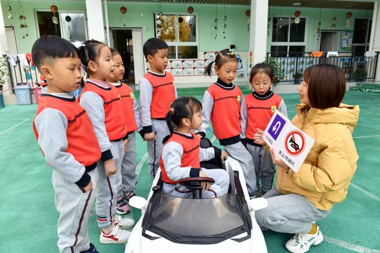 2021年12月1日，湖北省宜昌市秭归县金苹果幼儿园老师给孩子们讲解交通安全知识。