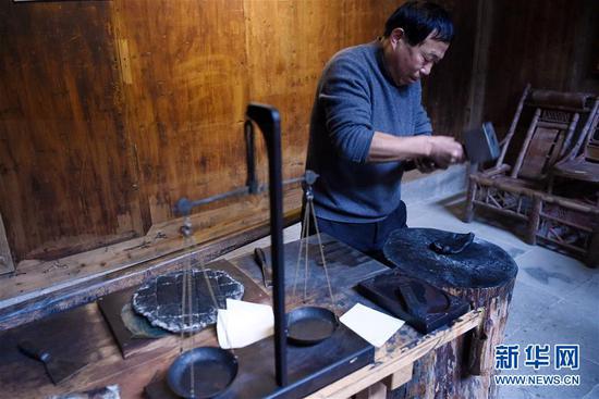 1月8日，在安徽省黄山市徽州区呈坎村，63岁的制墨师吴成林在制作徽墨。
