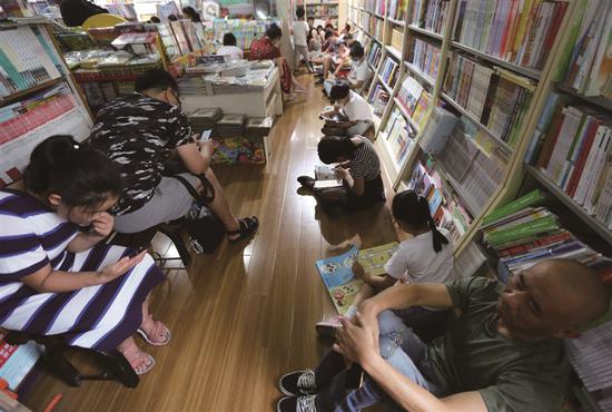 7月28日,南京一大型书店内,家长陪孩子看书纳凉。新华报业视觉中心记者 宋宁 摄