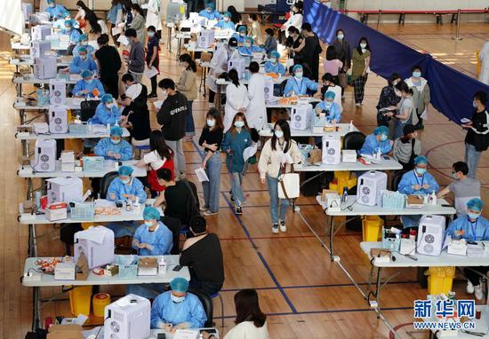 2021年3月28日,在华东师范大学闵行校区体育馆内,师生们在接种新冠疫苗。新华社记者 刘颖 摄