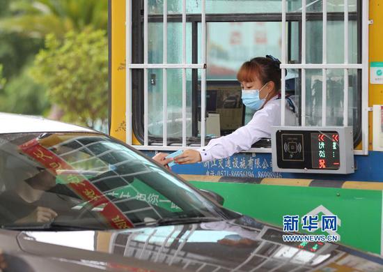 5月6日,贵州省铜仁市玉屏侗族自治县沪昆高速玉屏收费站的收费员在收取过往车辆过路费。 交通运输部4月28日发布关于恢复收费公路收费的公告,经国务院同意,自2020年5月6日零时起,经依法批准的收费公路恢复收费(含收费桥梁和隧道)。 新华社发(胡攀学 摄)