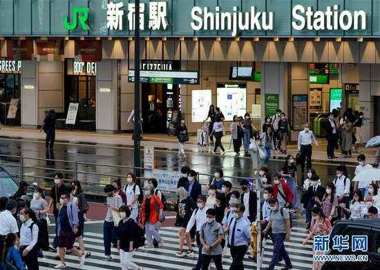 7月8日,人们戴着口罩在日本东京新宿车站附近出行。新华社发(克里斯托弗·朱摄)