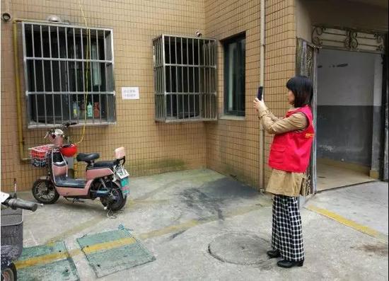 新北区三井街道飞龙社区网格员在用手机APP采集治理信息
