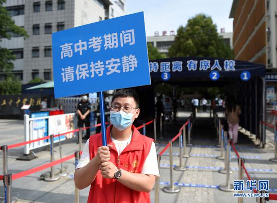 6月7日,在安徽省合肥市五十中学天鹅湖校区考点,志愿者在考场外维持秩序。新华社记者 周牧 摄