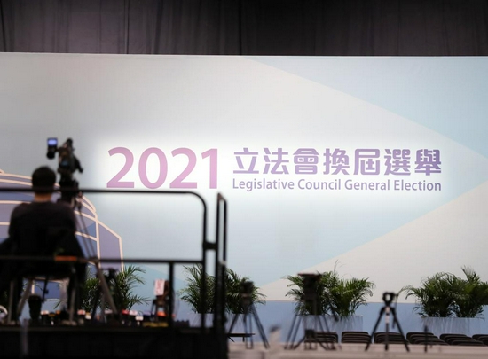 12月19日,在香港会展中心的新闻中心,一名工作人员在调试机器。新华社记者 李钢 摄