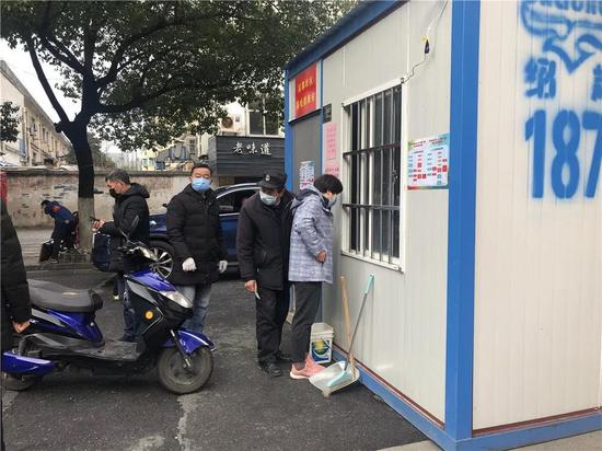 出入小区的居民凭身份证有序排队办理出入证