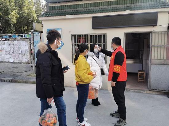 党员志愿者为居民测量体温,体温正常方可进入小区