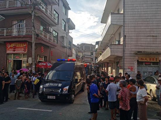 8月16日下午5时许，警方押解疑凶曾春亮离开厚坊村。 新京报记者 王飞 摄