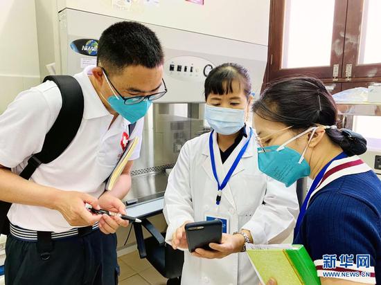 5月10日,中国抗疫专家组考察老挝北部琅勃拉邦省医院病毒检测实验室。新华社发(农丽春摄)