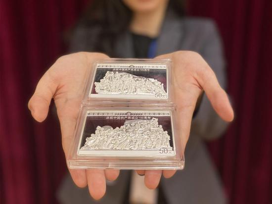 (一名金币总公司员工向记者展示两枚150克银币。新华社记者吴雨 摄)
