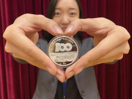 (一名金币总公司员工向记者展示1枚30克银币。新华社记者吴雨 摄)