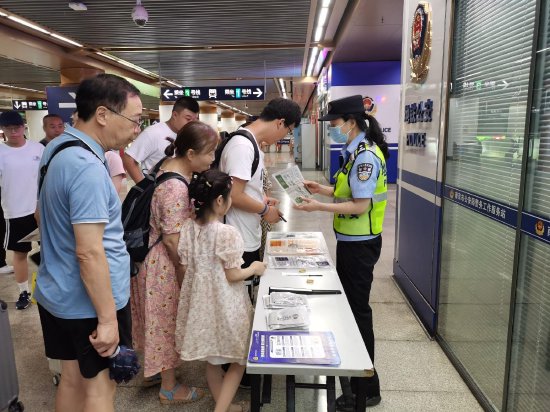 地铁公安分局民警在地铁站内向乘客宣传反诈知识。