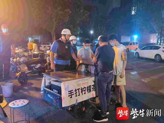 18岁小伙(右一)凌晨占道摆摊,城管执法人员已发查处取缔
