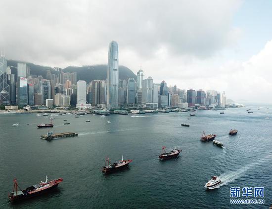 7月1日,插满旗帜的渔船在香港维多利亚港巡游(无人机照片)。新华社记者 李钢 摄