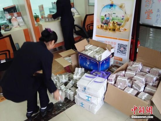 11月19日,山东省日照市日照银行内,工作人员在清点40万元零钱。