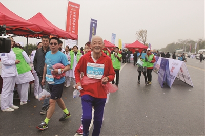 宫联康老人跑过赛程终点。高峰 摄