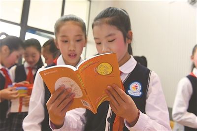 图为孩子们在仪式现场阅读活动赠书。 新华报业视觉中心记者 邵 丹摄