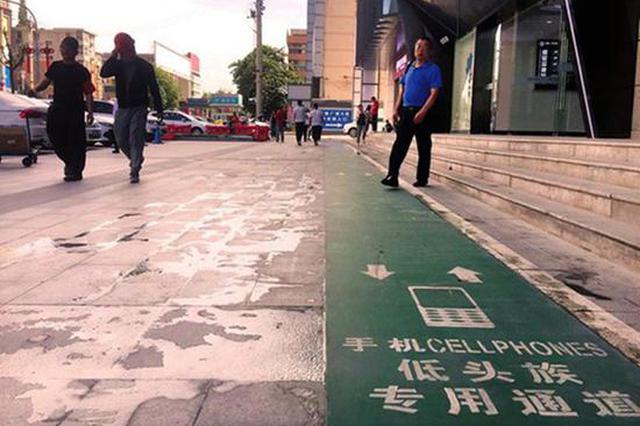 西安“低头族专用通道”引争议：鼓励走路玩手机？