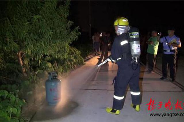 老人烧饭煤气罐着火 消防员冒着生命危险拎出煤气罐