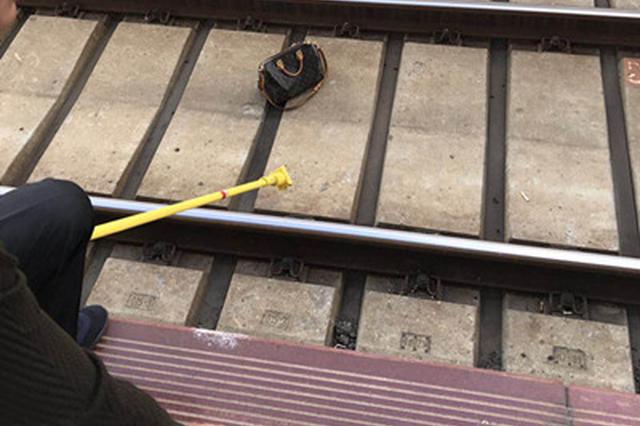 站台上女子只管玩手机 神行李箱被吹到铁轨上