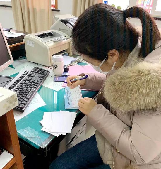 街道党政办工作人员为核对人员信息,为出入证登记做好前期准备工作