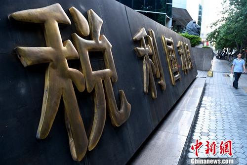 资料图:厦门市民从税收宣传标语旁经过。中新社记者 张斌 摄