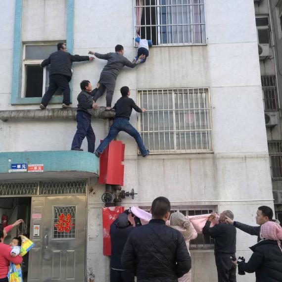 3岁娃身子悬在窗户护栏外 邻居搭起“最美人梯”施救