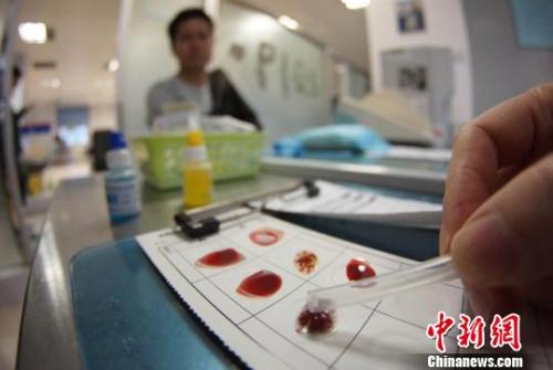 资料图:工作人员对献血人员的血样进行血型检验。 王昊阳 摄