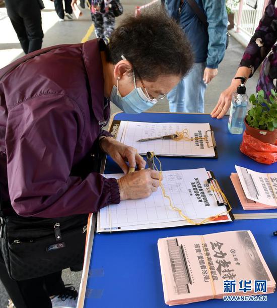 3月11日,在香港街头,香港市民签名支持。新华社记者 卢炳辉 摄