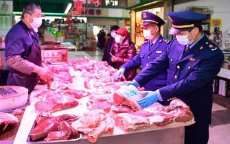 2021年2月5日，浙江省湖州市吴兴区市场监管局工作人员在农贸市场检查肉类（新华社记者黄宗治 摄）