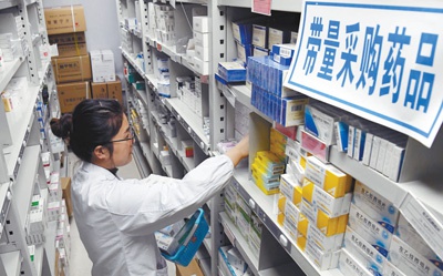 江西南昌大学第二附属医院药房内,医师正在带量采购药品的药架前为患者取药。时 雨 摄