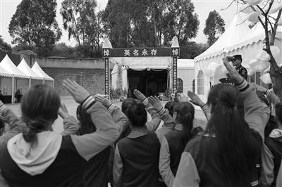 4月3日上午，民众前往西昌市殡仪馆祭奠英雄。一队小学生在灵堂门口向英雄们敬礼。