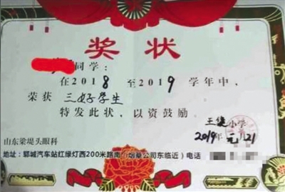 一张落款为王集小学的小学生奖状上,印上了“山东梁堤头眼科”的广告。新京报我们视频截图