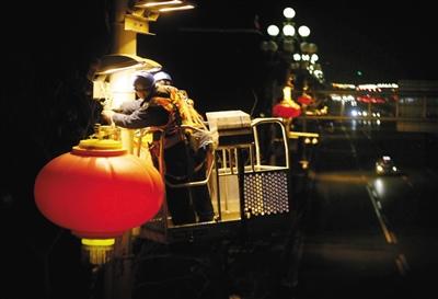 1月21日晚11时30分，电力工人在长安街安装春节灯笼