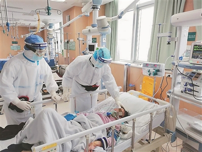 江苏省人民医院呼吸与危重症医学科副主任、主任医师，武汉市第一医院国家医疗队联合专家组组长齐栩（右一）和同事在武汉市第一医院重症监护病区给危重症患者进行检查。