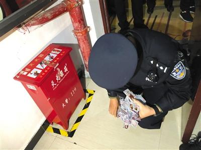 5月6日晚，执法人员在酒店区域内的灭火器箱内查获数百张招嫖卡片。 本版摄影/新京报记者 游天燚
