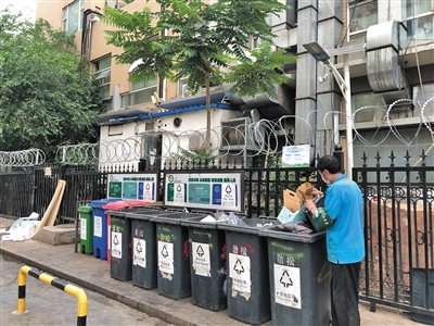 朝阳区百环家园小区,垃圾分类志愿者现场将居民扔在其他垃圾桶内的可回收垃圾分类出来。