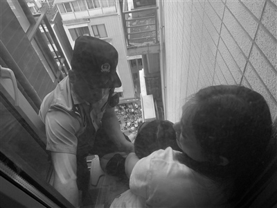民警徒手攀爬到该户空调外机处救母女。