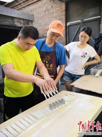 任晓猛、任文亚夫妻正在自家租住的小院里教授学员如何切面。中国青年报·中国青年网记者 邢婷/摄