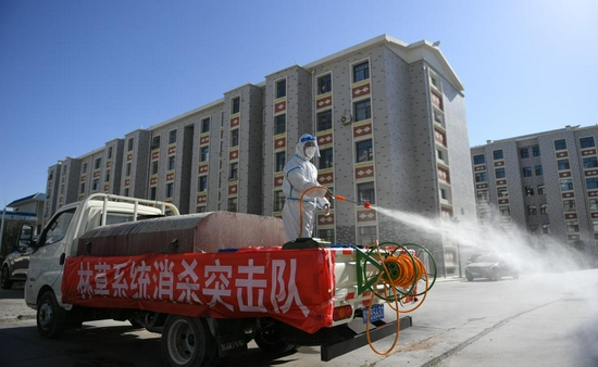 10月27日,包联干部章保成在内蒙古额济纳旗达来呼布镇居延名郡小区进行消杀。新华社记者贝赫 摄