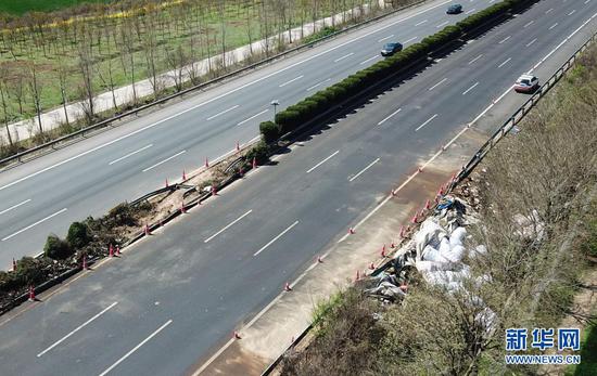 4月4日，事故现场路面已清理完毕，恢复通行。但隔离栏外仍有大量遗撒的货物等待清理（无人机照片）。新华社记者 杨绍功 摄