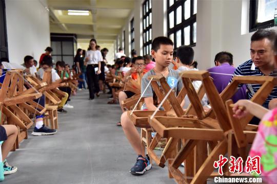 8月16日，游客在佛山南海丝厂的研学基地体验蚕桑丝织技艺。　曾令华 摄